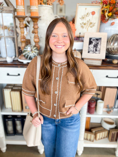 brown cardigan with buttons trimmed with white stitching 