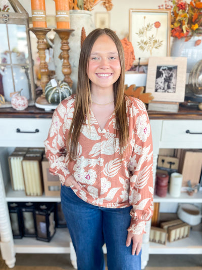 stunning long sleeve camel color top with white and red floral pattern