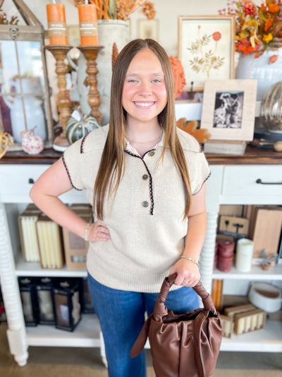 stunning taupe sweater with cap sleeves, a collar, and button down closure at the neckline 