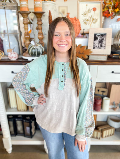 mint and grey causal top with floral accents on the sleeves and buttons down the front 