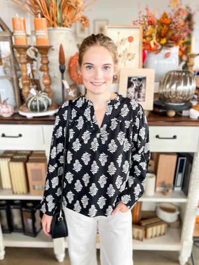 long sleeve black floral top with ruffle neckline and v-neck