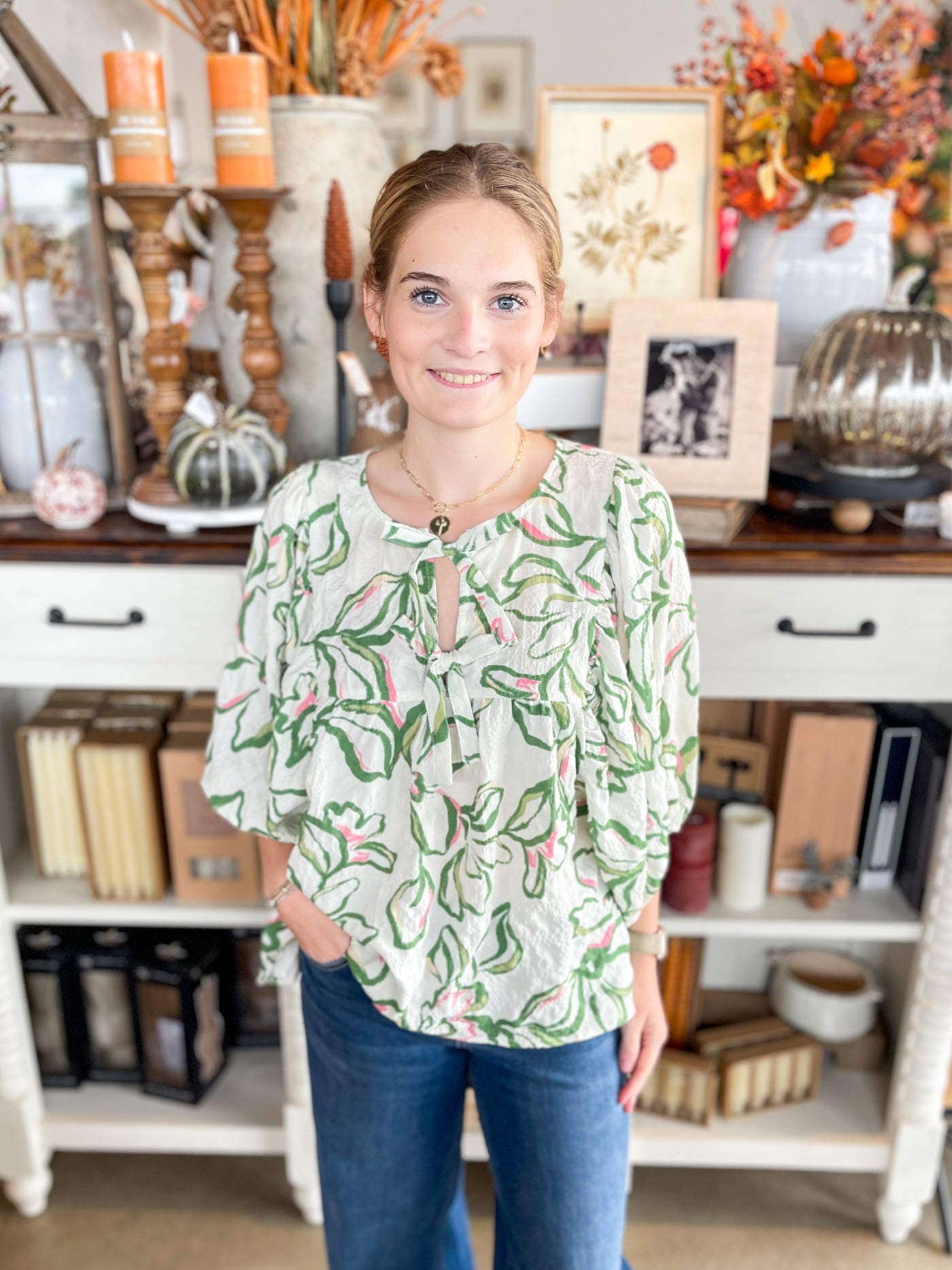 green and white floral long sleeve puff top with pops of pink and bows at the neckline 